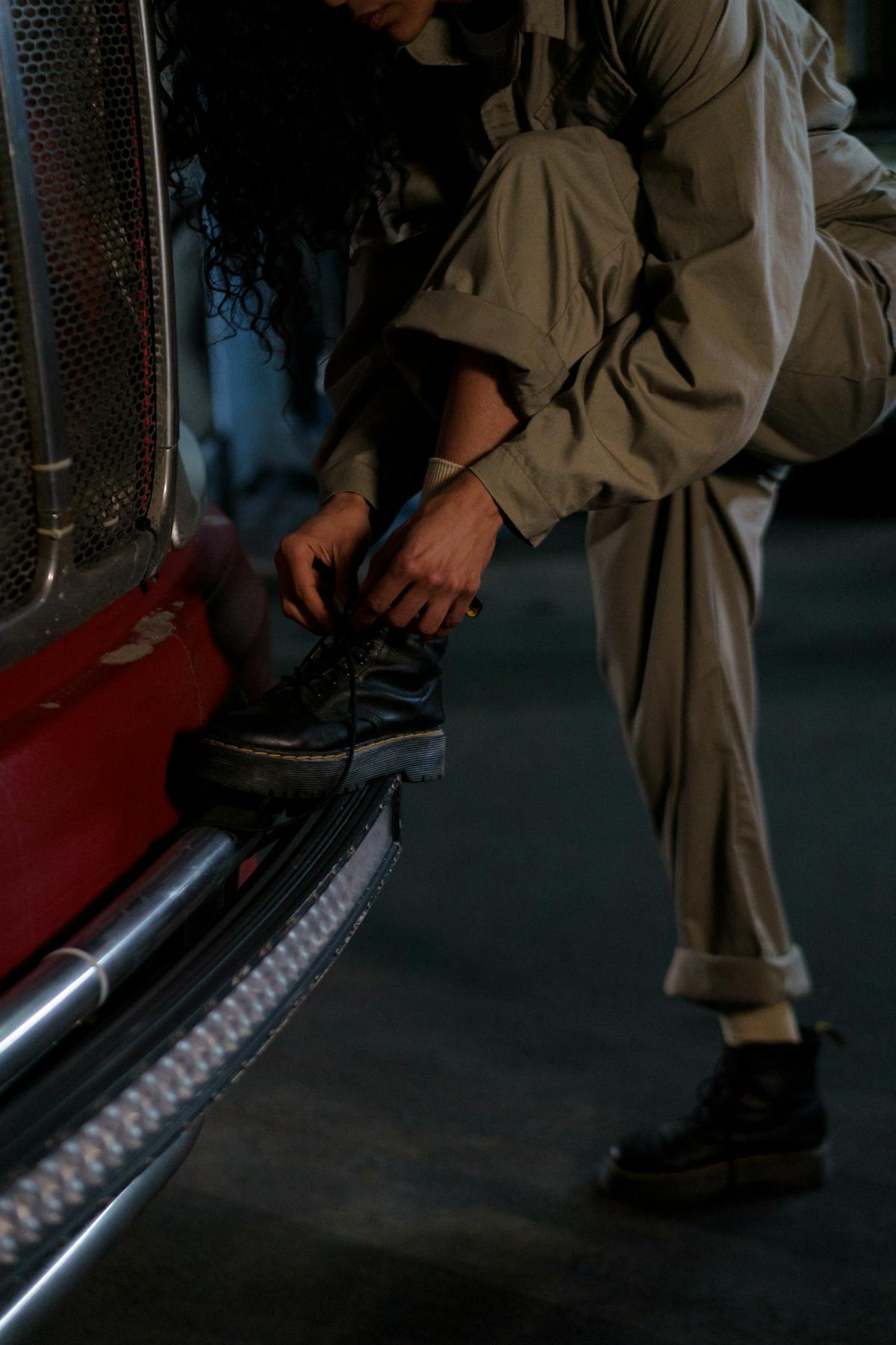 Professionnelle en tenue de travail qui lace ses chaussures de sécurité