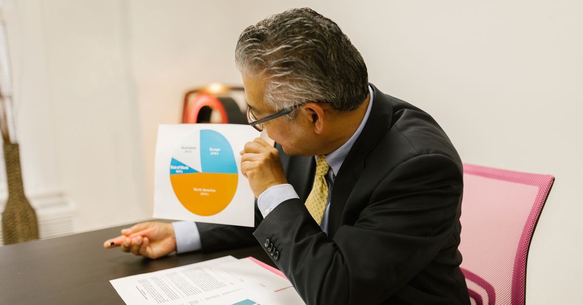 Directeur financier examinant des bilans et rapports financiers dans son bureau