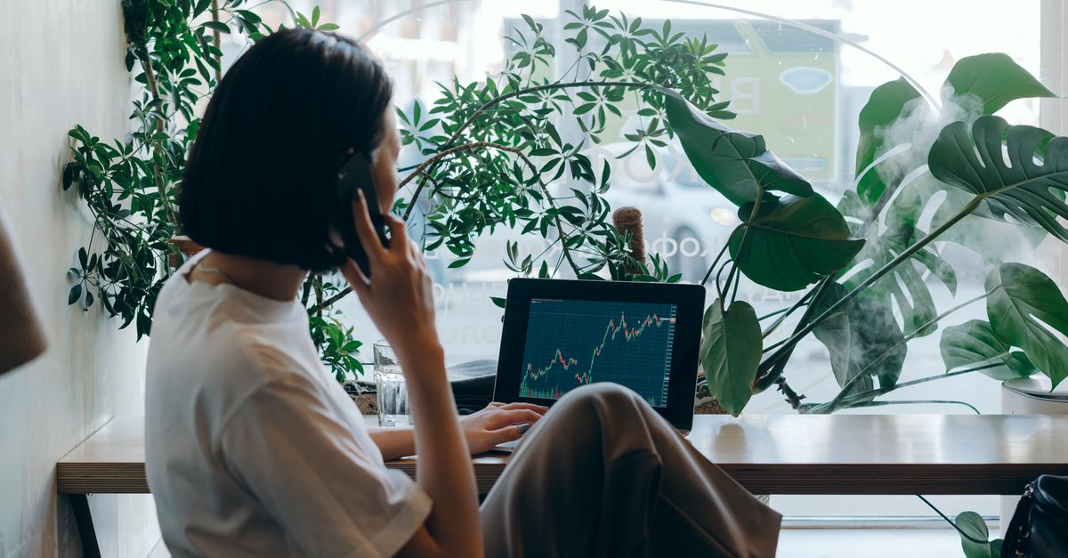 Professionnel en finance étudiant des graphiques et des données financières sur plusieurs écrans