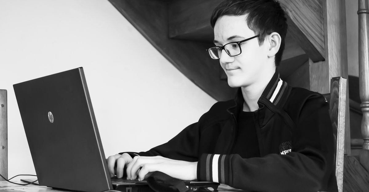 Étudiant avec un ordinateur portable dans une bibliothèque universitaire, gestion de son budget