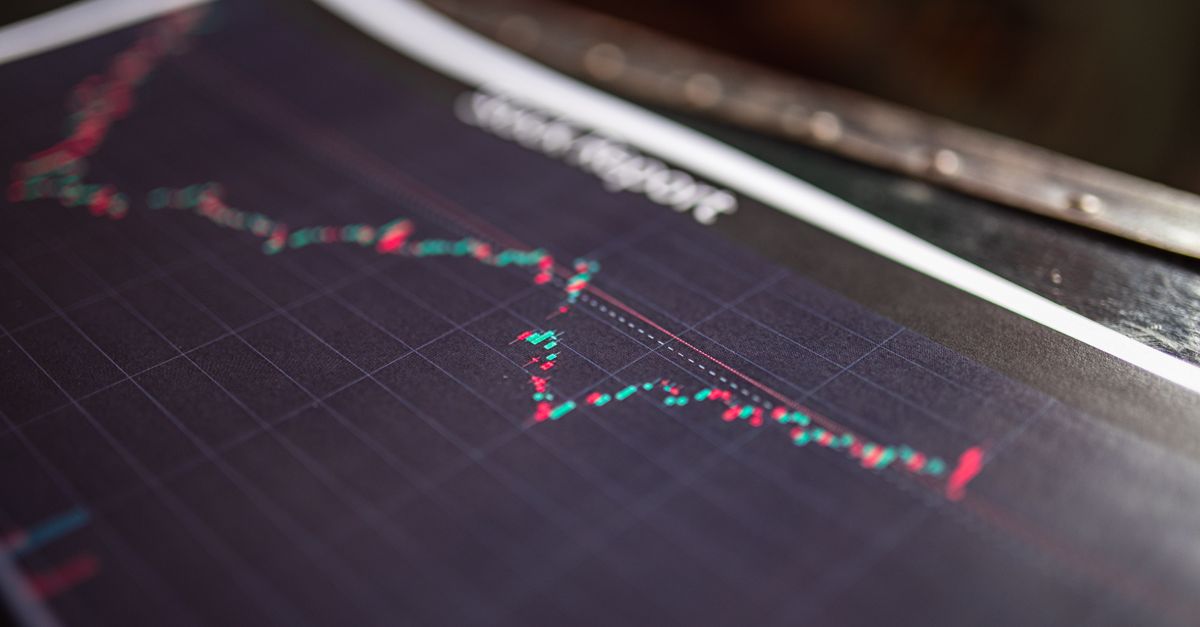 Graphique boursier affiché sur un écran avec un investisseur analysant les courbes