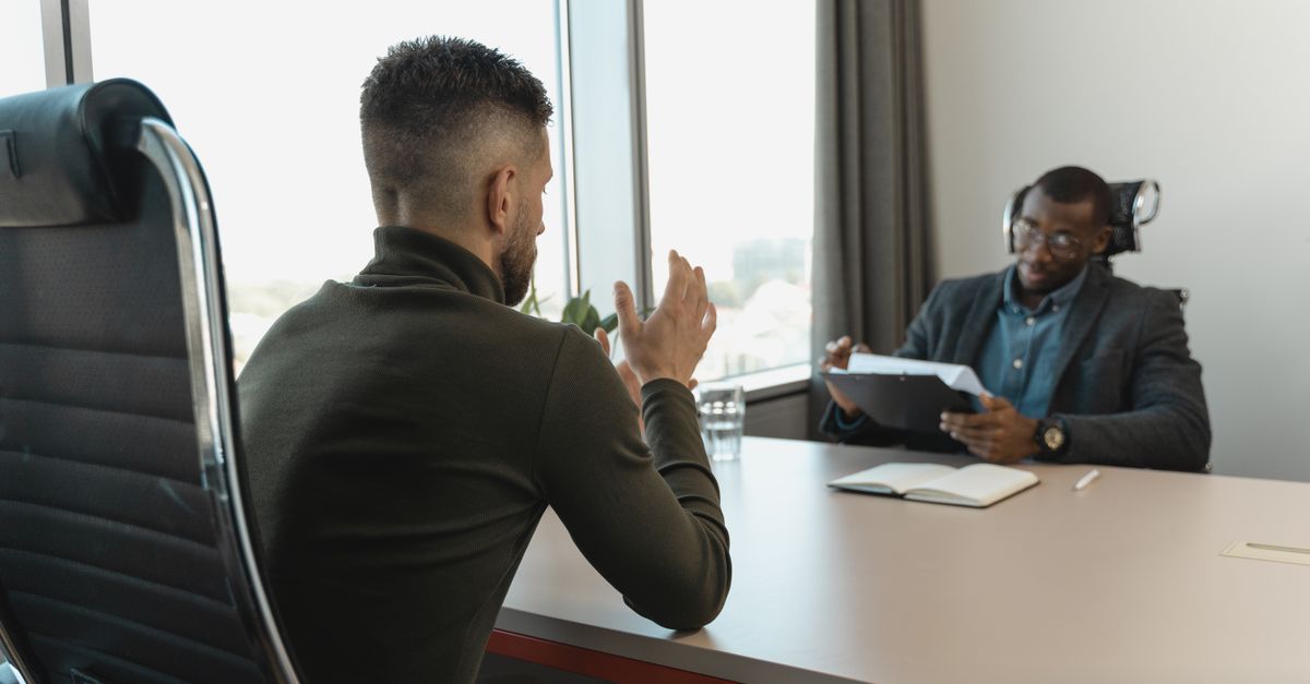 Manager conduisant un entretien de recrutement face à un candidat dans un bureau professionnel