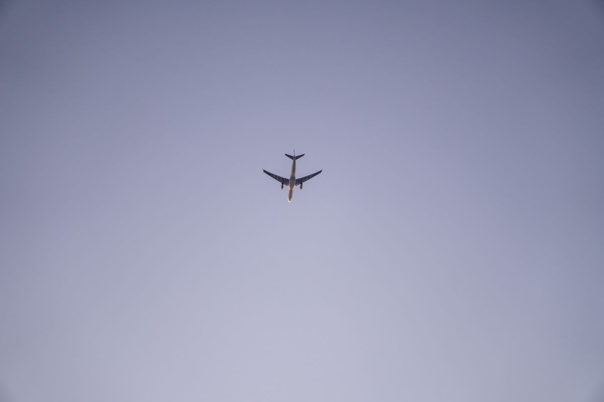 Avion de ligne commercial vu depuis le tarmac d'un aéroport, ciel dégagé