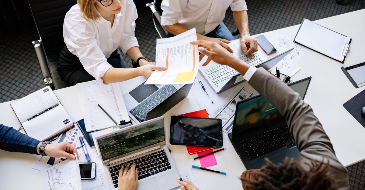 Collègues travaillant ensemble au bureau autour d'un ordinateur, illustration d'une communauté professionnelle sur abonnement