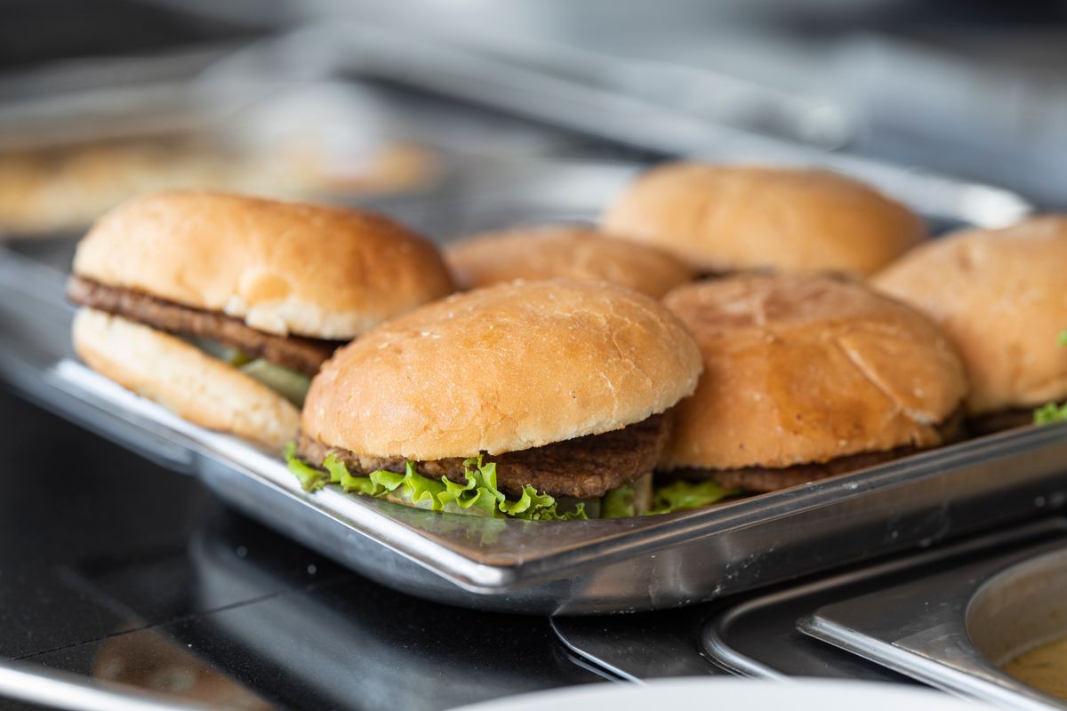 Préparation de burgers et frites dans une cuisine de restauration rapide