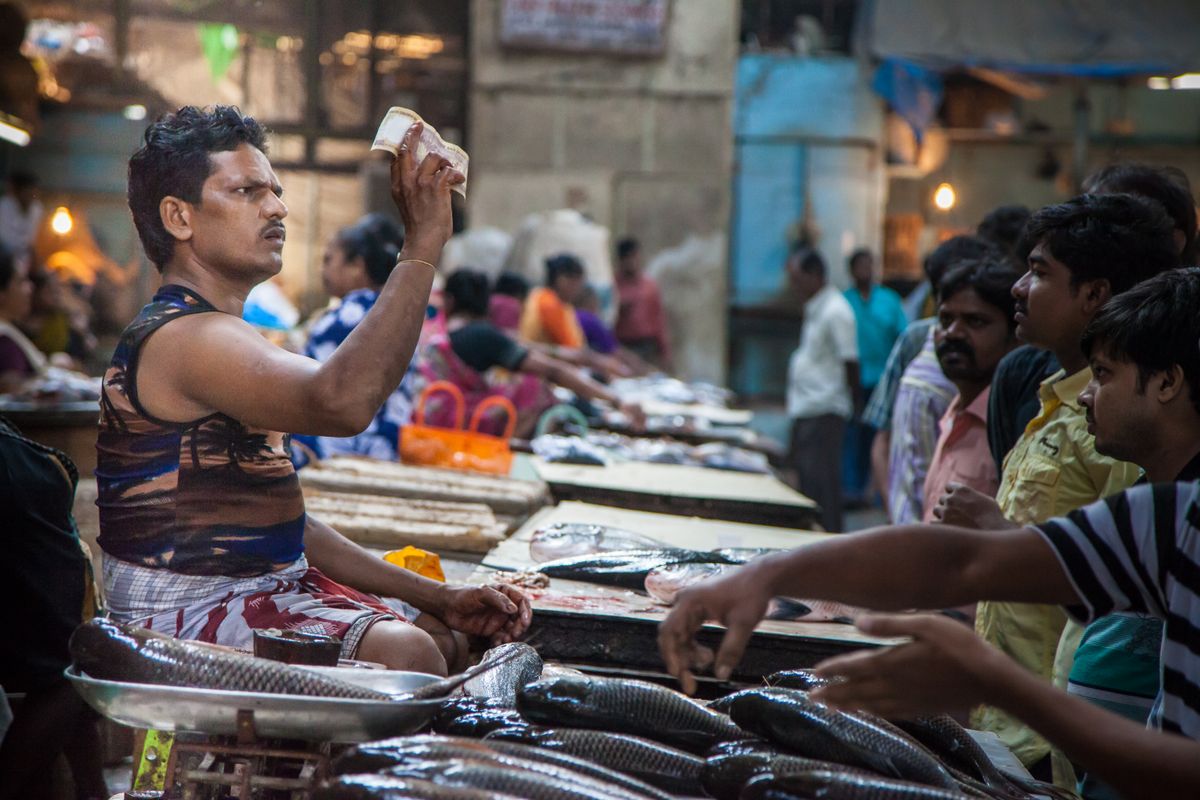 Marché aux poissons animé avec vendeurs et clients dans une rue de Mumbai en Inde