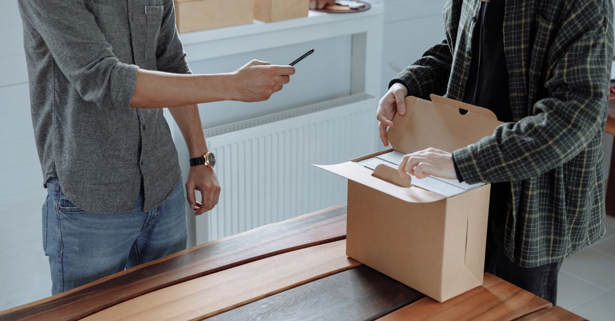 Personne ouvrant un colis en carton, illustration du contenu généré par les utilisateurs en e-commerce
